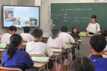 教室内で9年生が前に出て英語でキャラ弁について説明している様子