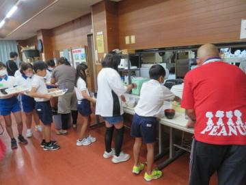 食事の片づけをする5年生