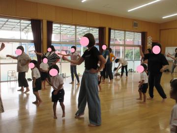 親子でハワイアンフラダンスの花の動きをしていることろ