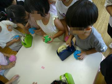 室内でお店屋さんごっこの品物をつくっている園児たちの様子