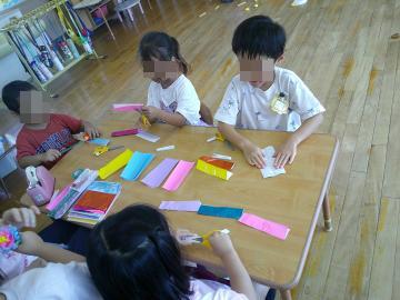 室内でお店屋さんごっこに必要な物を作っている園児たちの様子