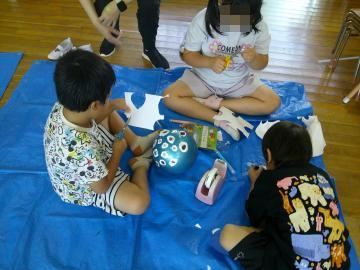 室内でごっこ遊びに必要なものを作っている園児たちの様子