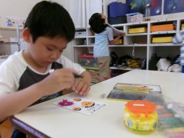 机に向かって幼児が祖父母へのメッセージを考えている様子
