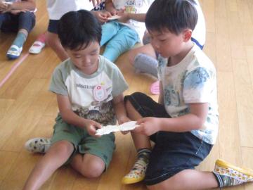牛乳パックで作った紙を4歳児へ触らせてあげる5歳児(2)