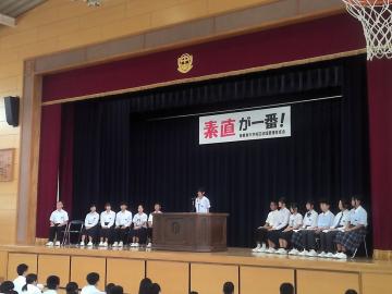 体育館の壇上で、立候補者が演説をしている様子