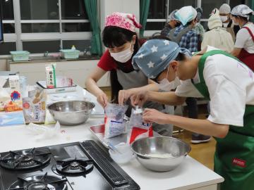 材料を計量カップなどではかっている様子