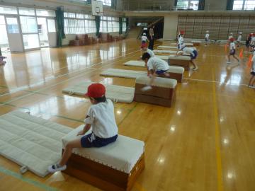 1年生が体育館内で跳び箱を飛んでいる様子