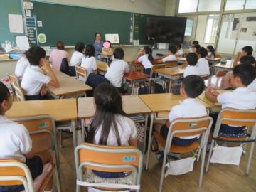 4年生が絵本の読み聞かせを聞くようす
