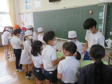 2年生の給食配膳を手伝う中学生