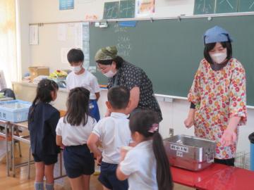 1年生の給食配膳を手伝う中学生