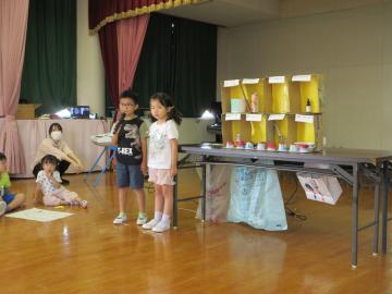 遊戯室内で4歳児が体験活動の発表をする様子