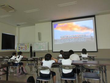室内のモニターに映された動画を見て環境について学ぶ園児の様子