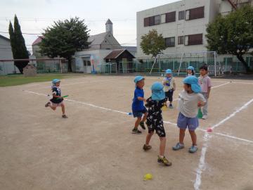 屋外で幼児がリレーをしている様子