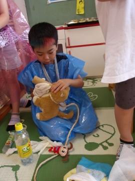 医者になりきった幼児が犬のぬいぐるみを治療する様子