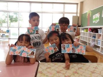 敬老の日に向けて書いたはがきを見せて写真を撮る様子