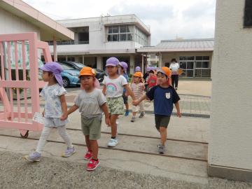敬老の日のハガキを投函しに行く幼児