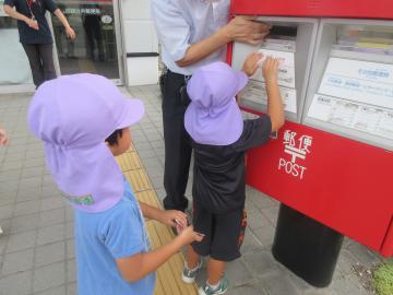 ハガキをポストに投函する幼児
