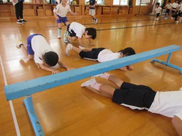 平均台くぐりをする幼児