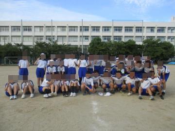 ありがとう運動に参加した生徒が、校舎をバックに二列に並んで集合写真を撮っています。