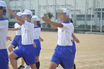 生徒が手と足を高く上げ、まっすぐ前を向き行進しています。