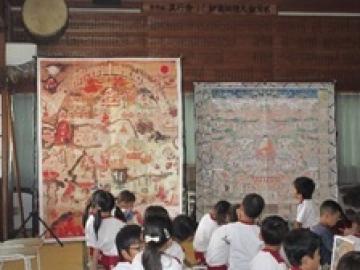 極楽浄土と地獄の絵を見る子ども達の写真