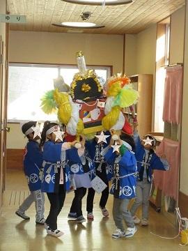 子どもたちがつくった屋台をかついでいます