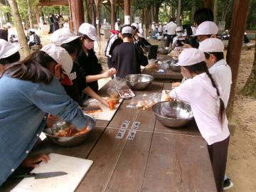 調理場で5年生が班で協力してカレーを作っている様子