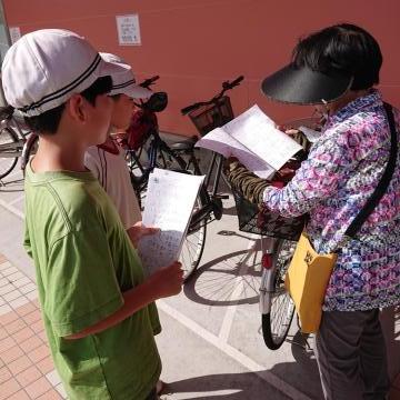 店の外で新聞を渡す児童の様子