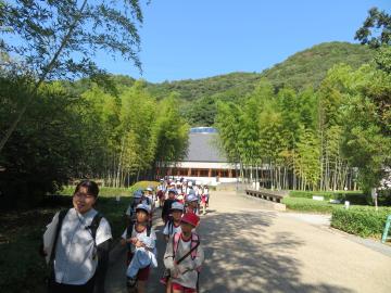 美しい竹林の奥の工芸館から退出する児童たちの様子