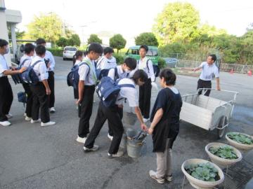 校舎内で掃除道具を準備して学校を出発する生徒たちの様子