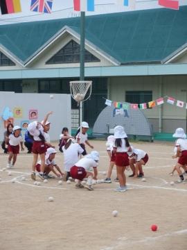 祖父母と園児が園庭で玉入れをしている様子