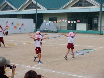 園庭で園児がフラフープをもって回っている様子