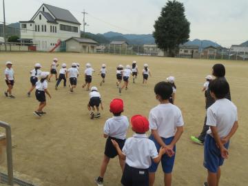 校庭で1年生とのお別れ鬼ごっこをする中学生の様子