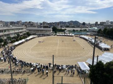 体育大会で生徒や保護者、教員が運動場に集まっている様子