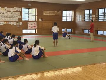体育館内でマット運動をする生徒たちの様子