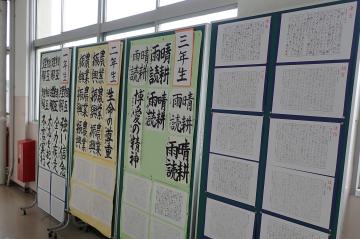 廊下の掲示板に書写作品が展示されている様子