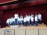 体育館の壇上で合唱する生徒たちの様子