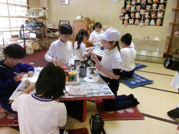 館内で独楽に絵付けをしている児童たちの様子