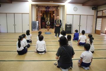 館内で住職さんの話を聞いている児童たちの様子