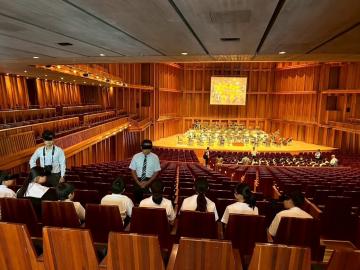 兵庫県立芸術文化センターの館内を見学する生徒たちの様子です。ホール内の客席に着席しています。