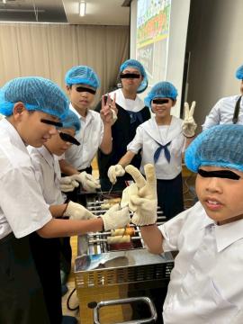 ニッスイ姫路総合工場での工場見学の様子です。生徒たちが製造機を使い、ちくわの製造体験をしています。