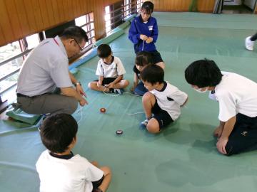 校長先生、9年生に見守られながらコマ回しをしている様子