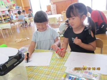 室内でトンボを製作している3歳児たちの様子