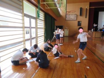 司会チームと校歌チームが体育館で座って打ち合わせ