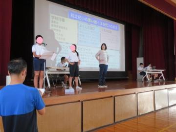 新体操服披露チームが体育館舞台上でリハーサルしている