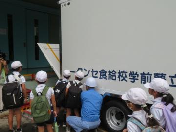 トラックのリフトをボタンで操作する2年生