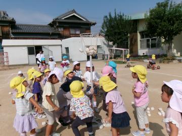 園庭で園児たちが玉入れをして遊んでいる様子