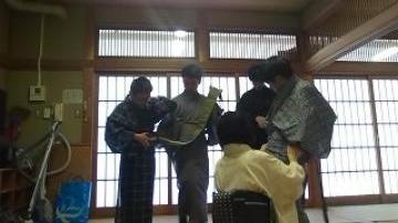 浴衣の着付けをしてもらう男子部員