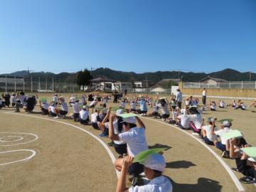 校庭で撮影の説明を聞く子どもたちの様子