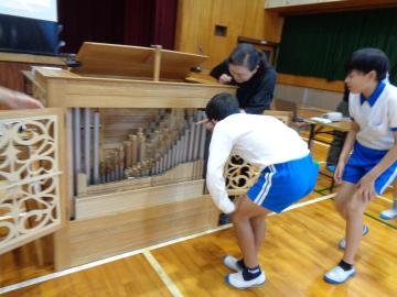 オルガンの中を覗く子ども達